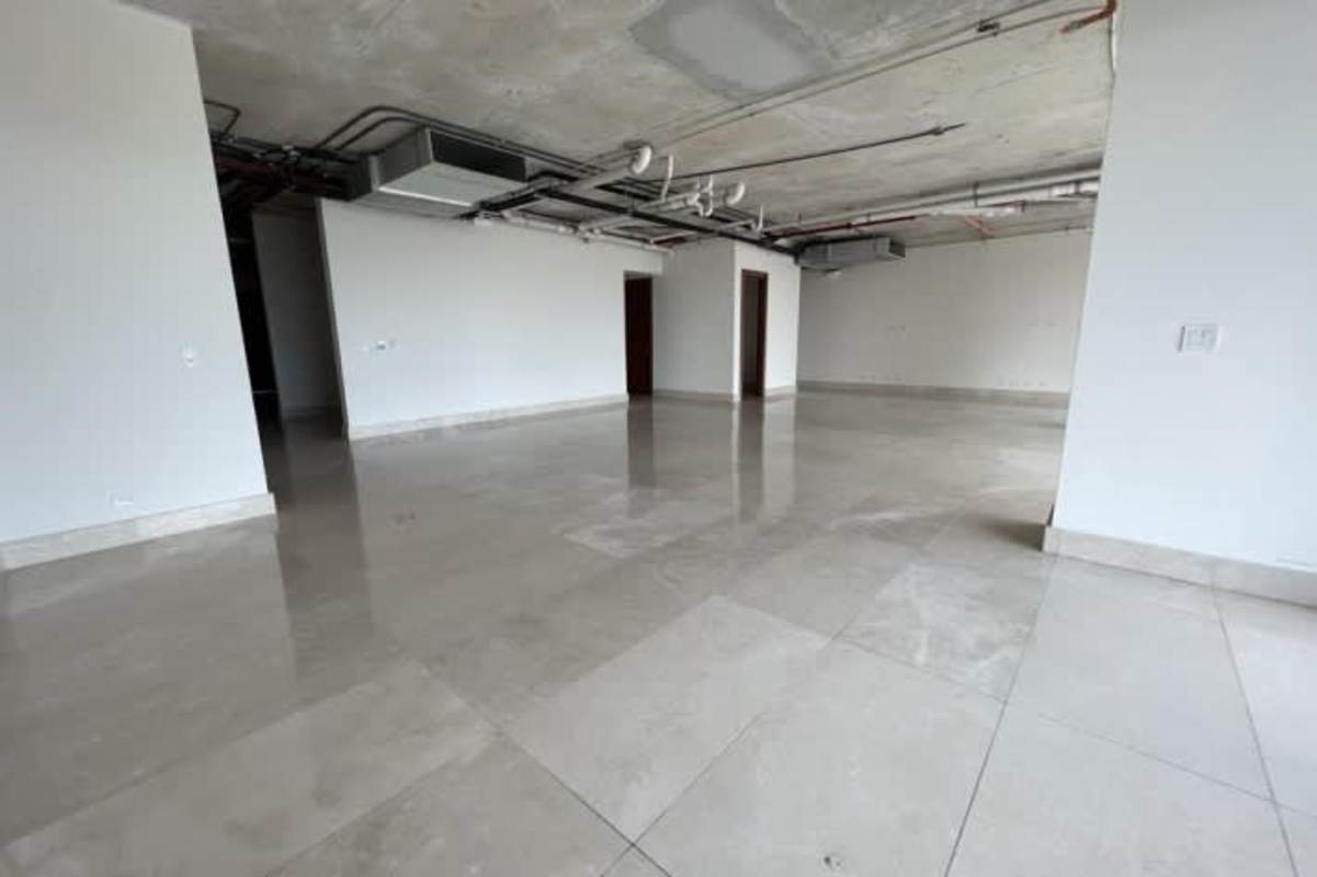 Open interior space with polished tile floors and exposed ceiling piping at Santa María Panama