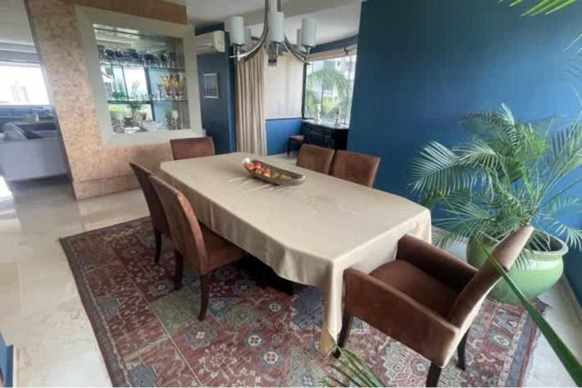 Large dining room with chandelier, blue accent wall, seating for eight in PH La Cresta Panama