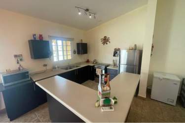 Single story modern house with large windows, covered terrace and grassy yard PH Villa Brisas Coronado Panama