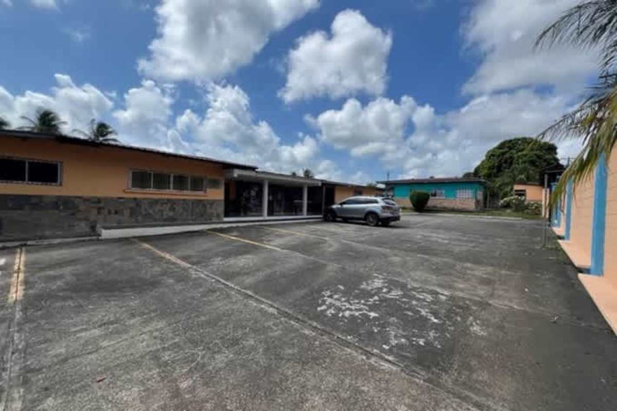 View over grassy playground yard with connected single-story buildings at former Aldeas SOS Colón Panama ideal for redevelopment