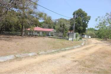 Single story house with red roof next to residential lot El Valle de Toscana Coclé Panama