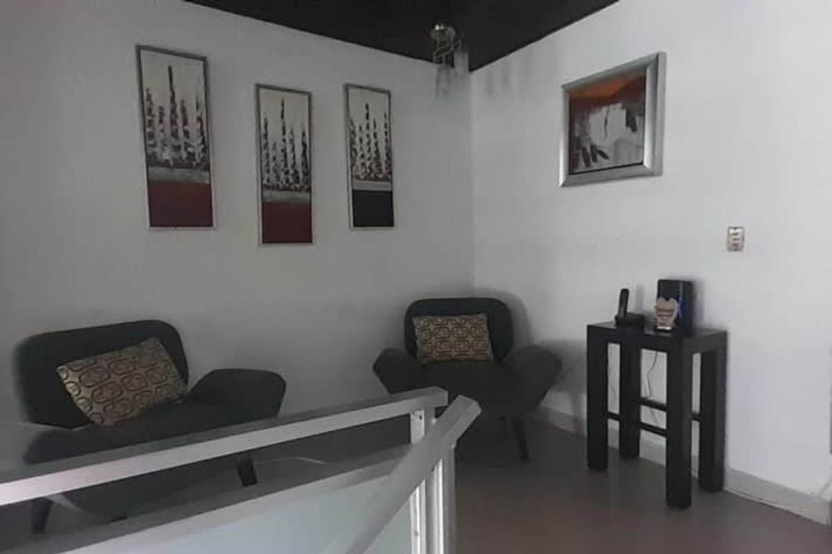 Small living room with armchairs, modern wall art, minimalist railing Betania multi-level house