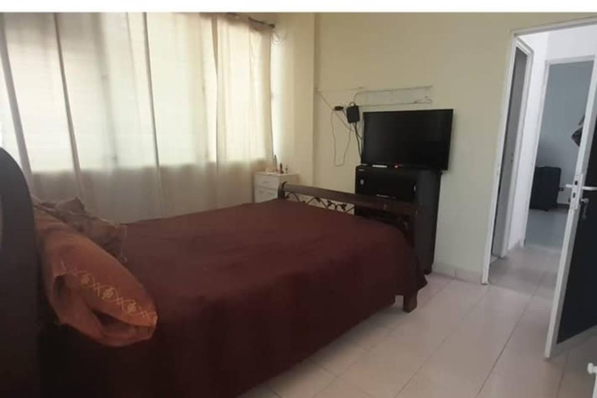 Bedroom space featuring mounted TV, large window with curtains Betania Los Ángeles house