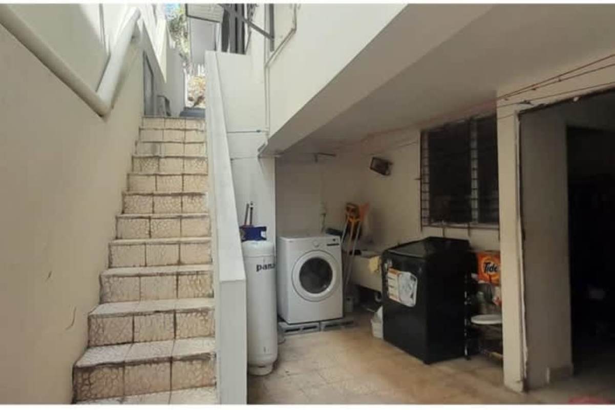 Laundry space under stairs with washing machine, utility sink Betania house sale
