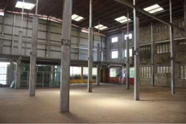 Manufacturing friendly industrial warehouse interior with glass-walled office and large space Aguadulce Panama
