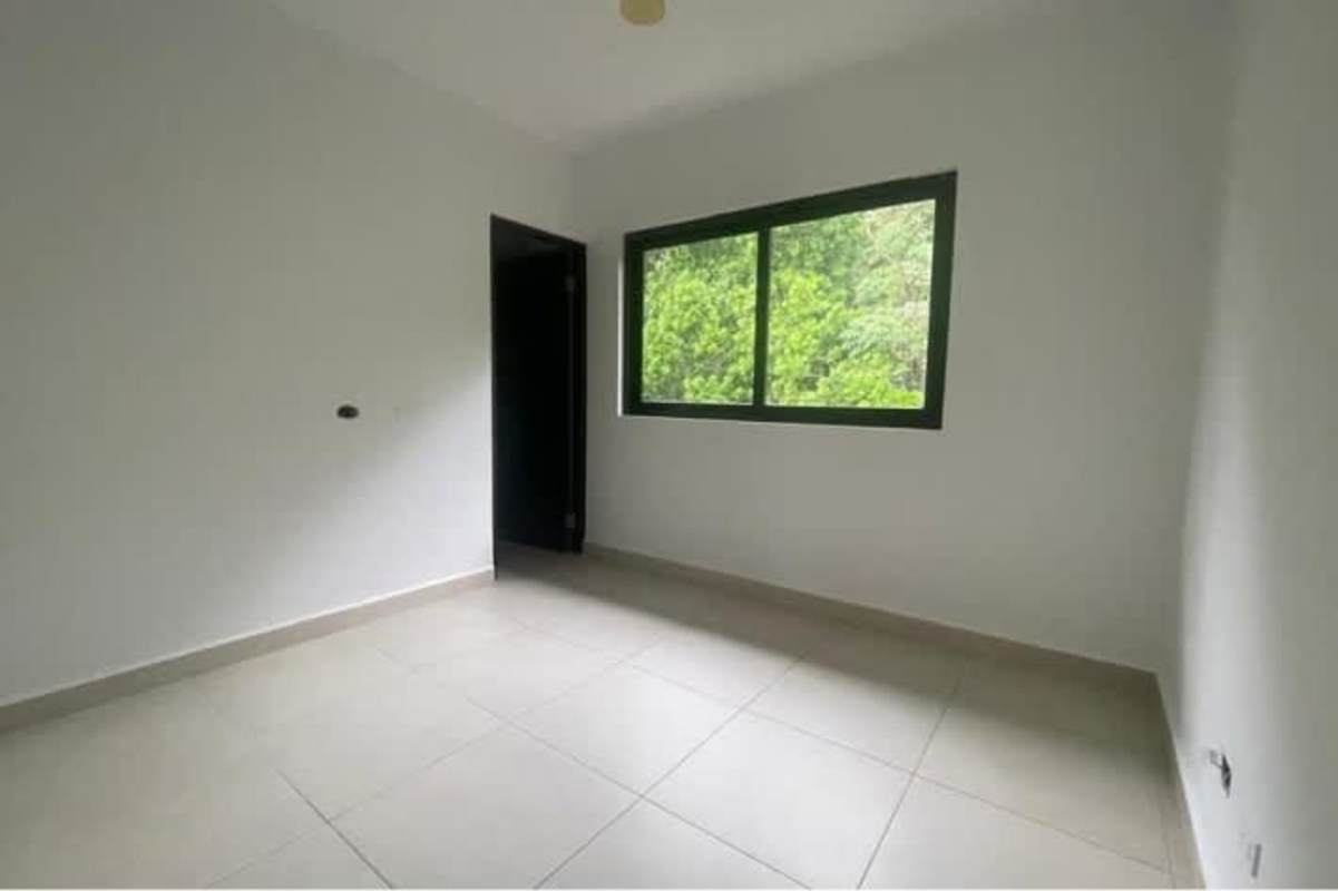Bedroom with large window tiled floors white walls in Albrook Gardens apartment Panama