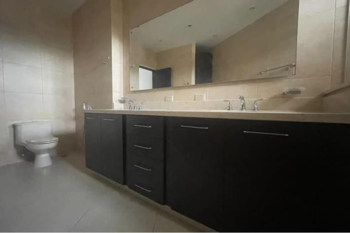 Spacious bathroom with large mirror double vanity and neutral decor in Panama City apartment
