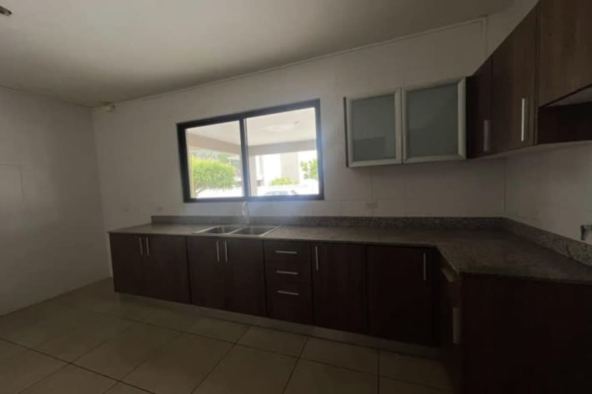 Contemporary kitchen with granite counters, dark wood cabinets, large window in PH Mont Blanc Brisas del Golf Panama