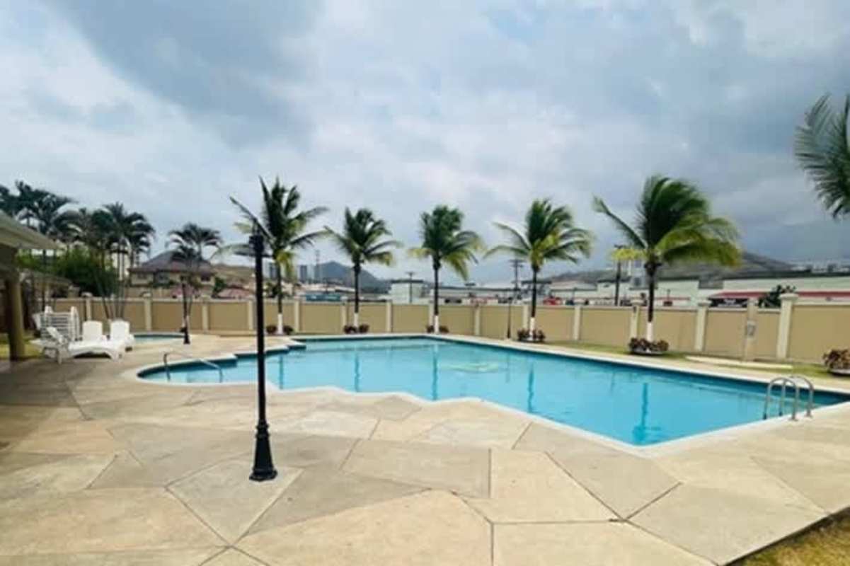 Sunny empty bedroom with large corner windows and ceiling fan house rental Condado del Rey Panama