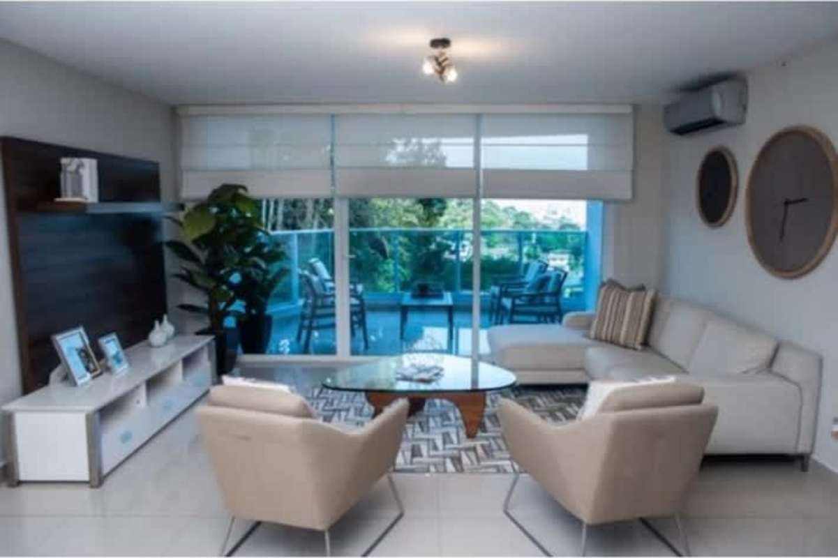 Residents relaxing by infinity pool with panoramic skyline sunset at PH Villa las Fuentes Panama City