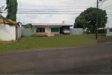 Single-level building with garage gate, grassy yard and trees El Trapichito La Chorrera