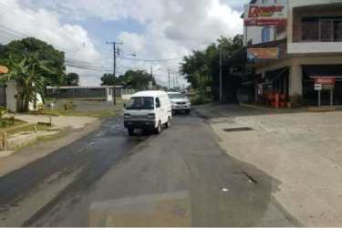 Commercial street with retail storefronts, cars, trees El Trapichito La Chorrera