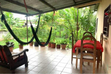 Exterior of family house with fenced yard and porch in Puerto Caimito Panama