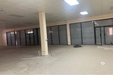 Interior of empty high ceiling industrial warehouse with fenced areas in La Chorrera