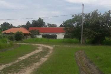 Country house with red roof surrounded by large grassy yard in Valle de Toscana Antón Panama