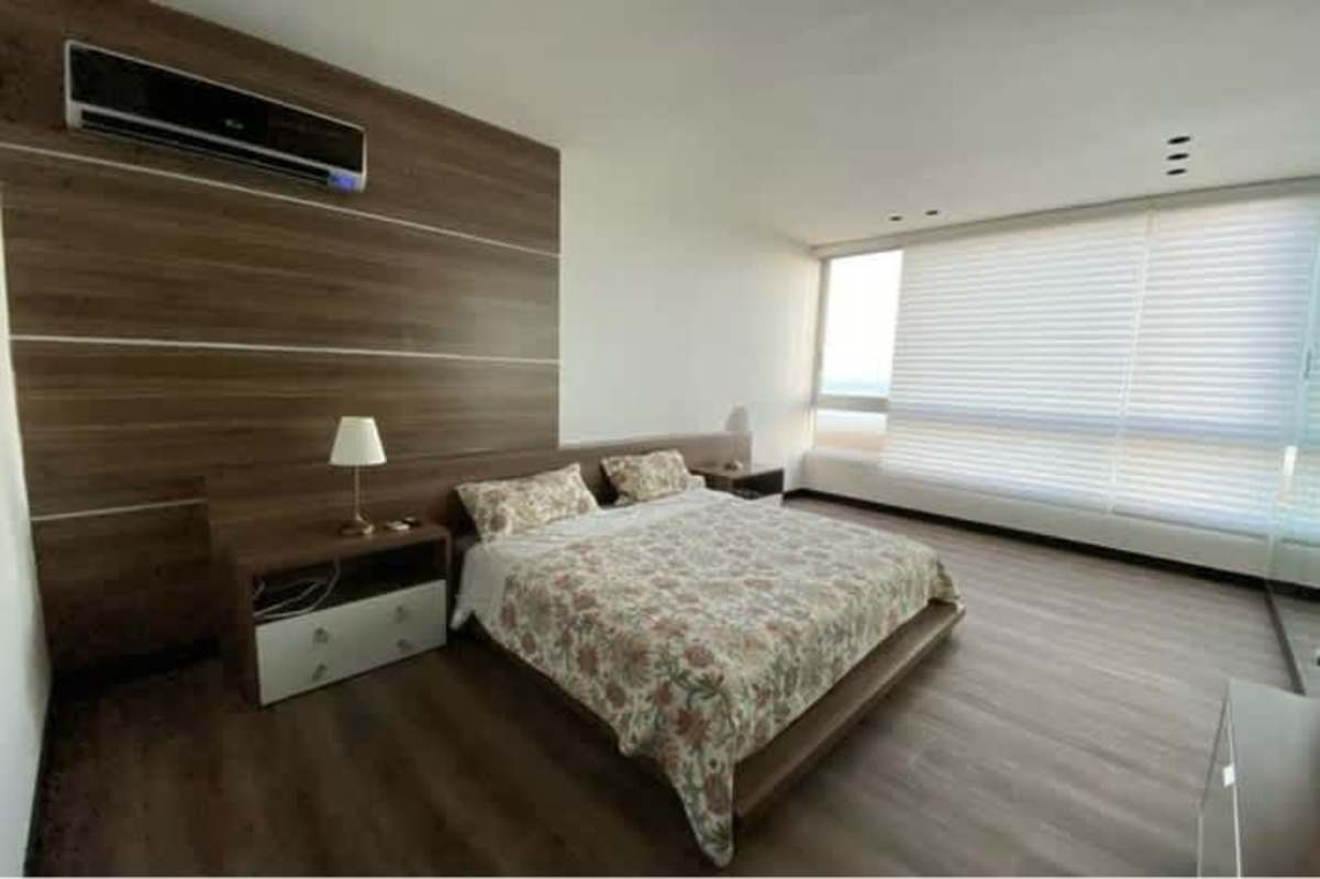 Modern bedroom with large window, wood accent wall, AC unit PH Serenade Costa del Este Panama