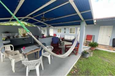House front with metal fence and yard on Panamericana road San Carlos Panama