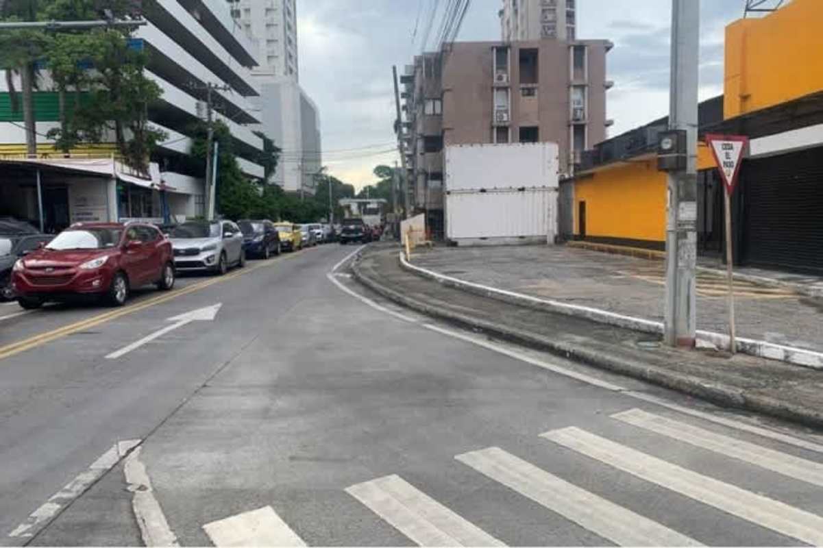 City street with retail units, apartments, vehicles and signage Via España Panama