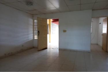 Simple kitchen with sink, cabinets and barred window in affordable Panama Oeste property