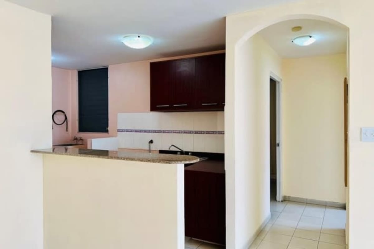 Modern apartment kitchen with granite, cabinetry, pass-through bar in Panama City