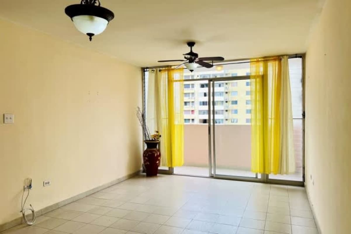 Laundry corner with utility sink, green window, and hose in Panama City rental apartment