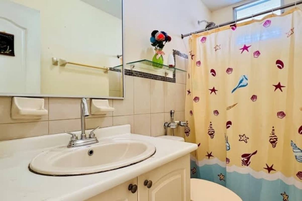 Bathroom with vanity, wall mirror, glass shelf, shower curtain Panamá City apartment rental