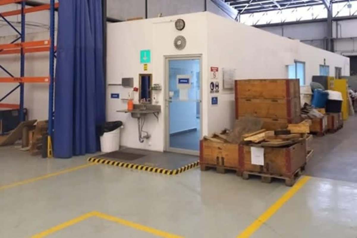 Warehouse area with wash station, partitioned office, crates and industrial racks Milla 8 Panama