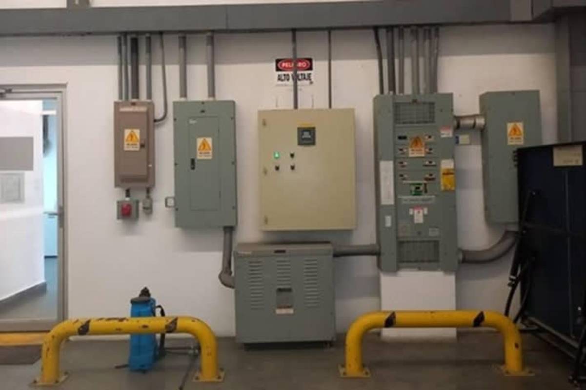 Industrial electrical utility room with high voltage panels and safety signs in warehouse Milla 8 Panama