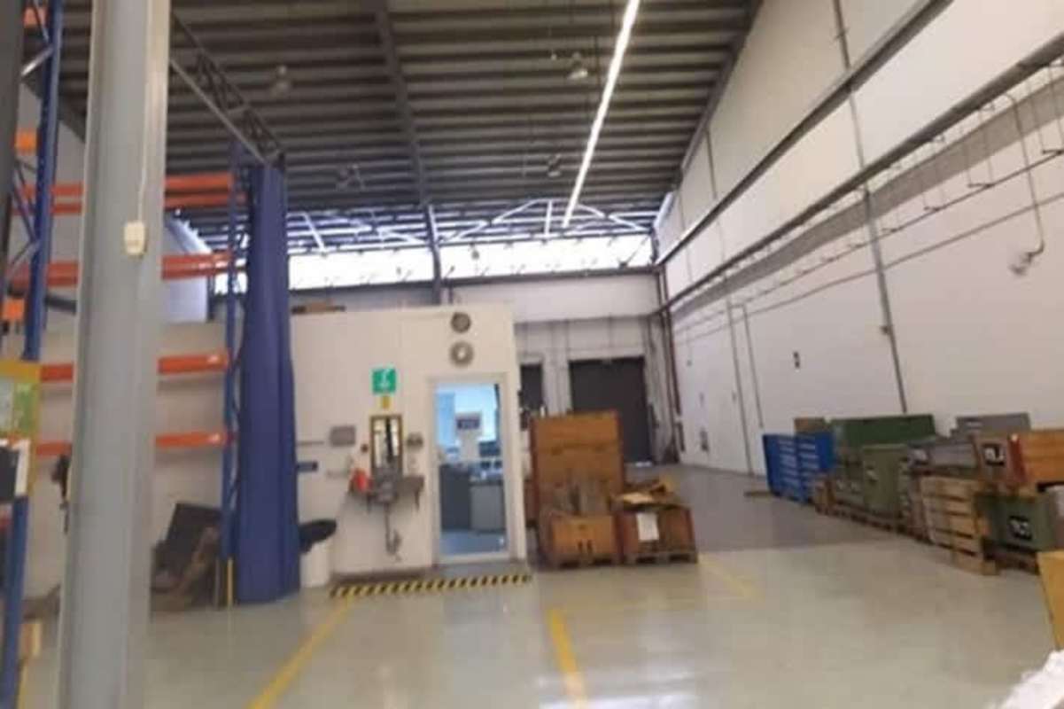 Large industrial warehouse interior with partitioned office, storage racks, high ceiling in Milla 8 Panama