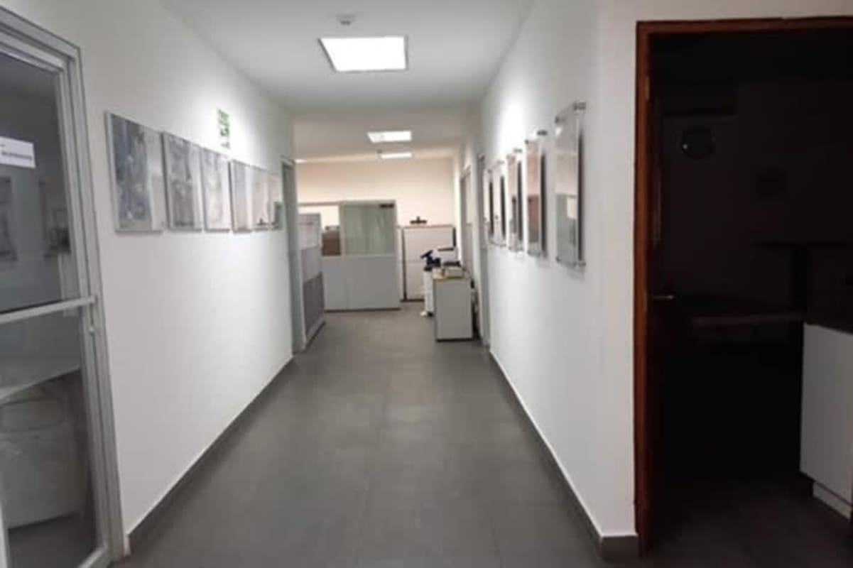 Long office hallway with framed pictures and tile flooring at Milla 8 industrial warehouse Panama