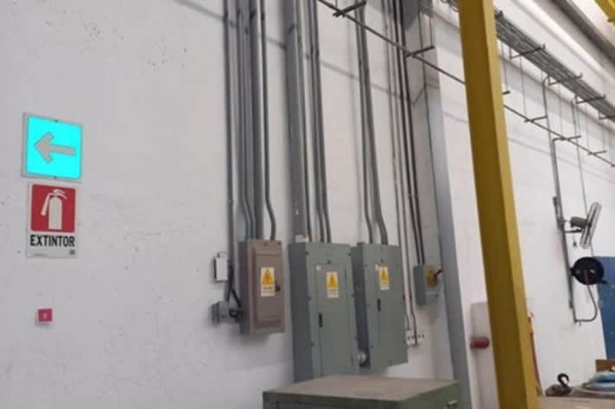 Warehouse with multiple electrical control panels, wiring conduits, and safety signage Milla 8 Panama