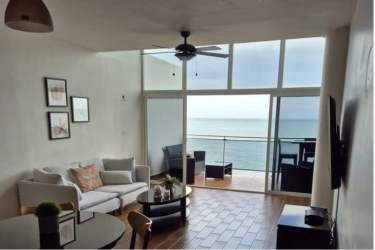 Living room with floor-to-ceiling windows and balcony overlooking Pacific Ocean PH Miramar Loft