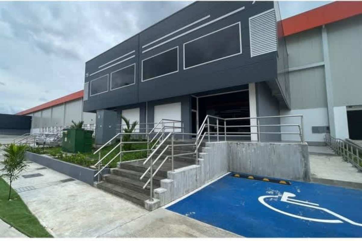 Modern industrial warehouse exterior with ramps, loading docks, ample parking in free trade zone Panama City