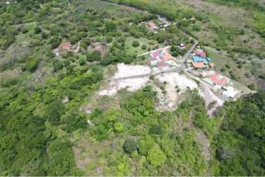 Lush green vacant plots with scattered homes in coastal Panama