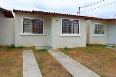 Living room with teal sofa and open kitchen concept in Residencial Palo Alto Penonomé