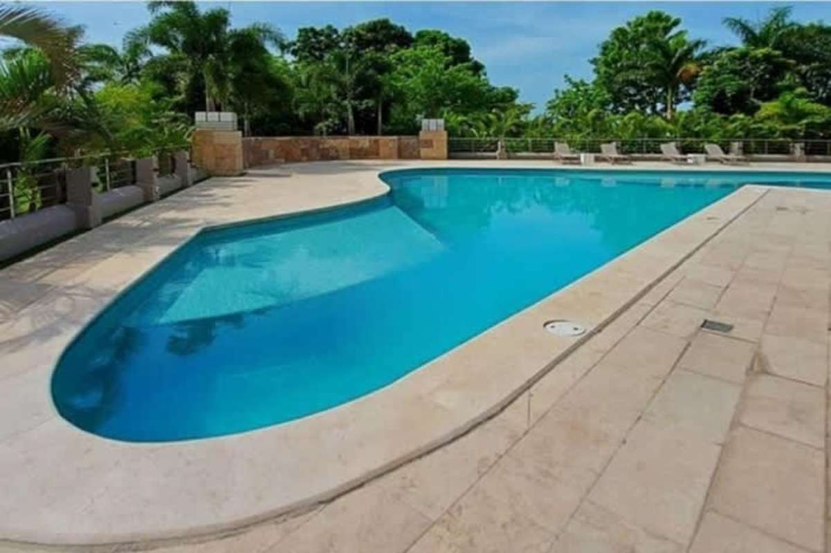 Modern resort-style swimming pool amid tropical landscaping at Santa María Panama