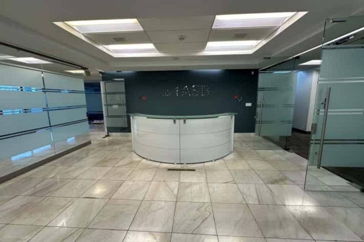 Modern office reception with marble flooring, glass walls, and curved desk in Tower Financial Center on Calle 50 Panama