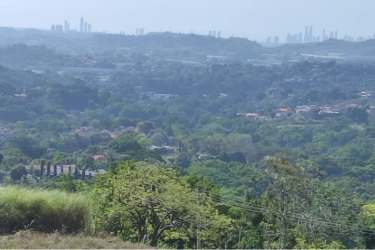 Landscape view of countryside terrain with greenery and distant city skyline in Panama Oeste