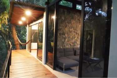 Deck with hammock modern rustic wood and glass villa overlooking green forest Panama