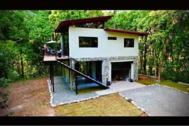 Two-floor modern tropical house with wooden deck surrounded by forest near Playa Morrillo Panama