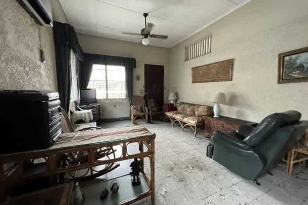 Office or bedroom with closet, tiled floors, window security bars in commercial house