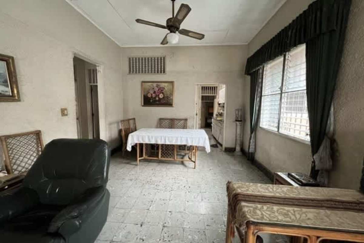 Basic kitchen space with granite-like counters, storage, window security bars commercial house Panama