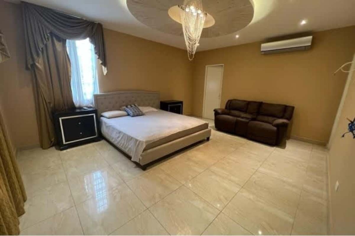 Large bedroom with seating, chandelier, AC luxury rental Panama City Hola Realty