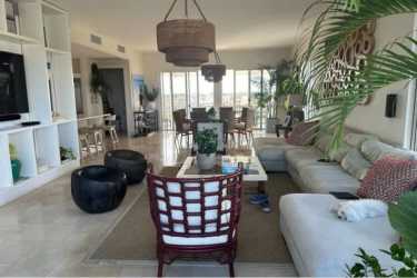 Bright spacious coastal-style living room with large windows in penthouse Buenaventura Panama