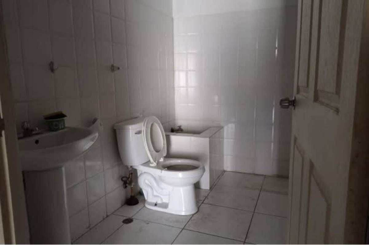 Basic warehouse bathroom with white tiles, sink and toilet Tocumen Office Storage