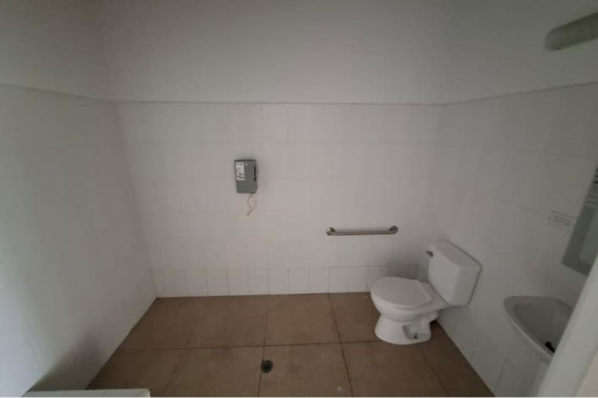 Simple commercial bathroom with tiled walls grab bar sink in Plaza Santa Fe Tocumen Panama