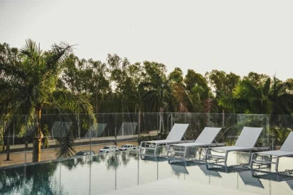 Modern infinity pool with hot tub and landscaped palm trees at PH The Reserve Costa del Este Panama