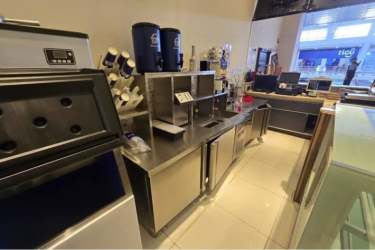 Cafe counter featuring coffee machines, glass display case and tiled floor inside Westland Mall Panama
