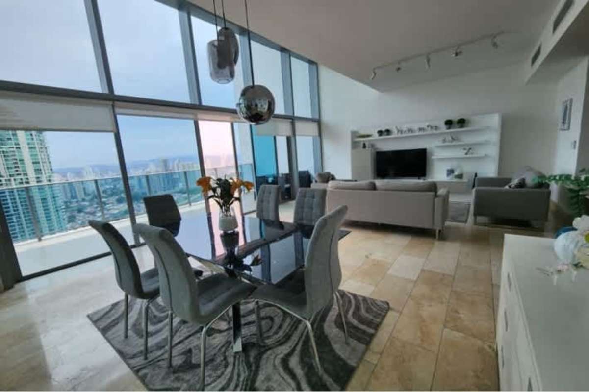 Spacious living and dining area with glass walls, ocean views, and modern decor at PH Pacific Point