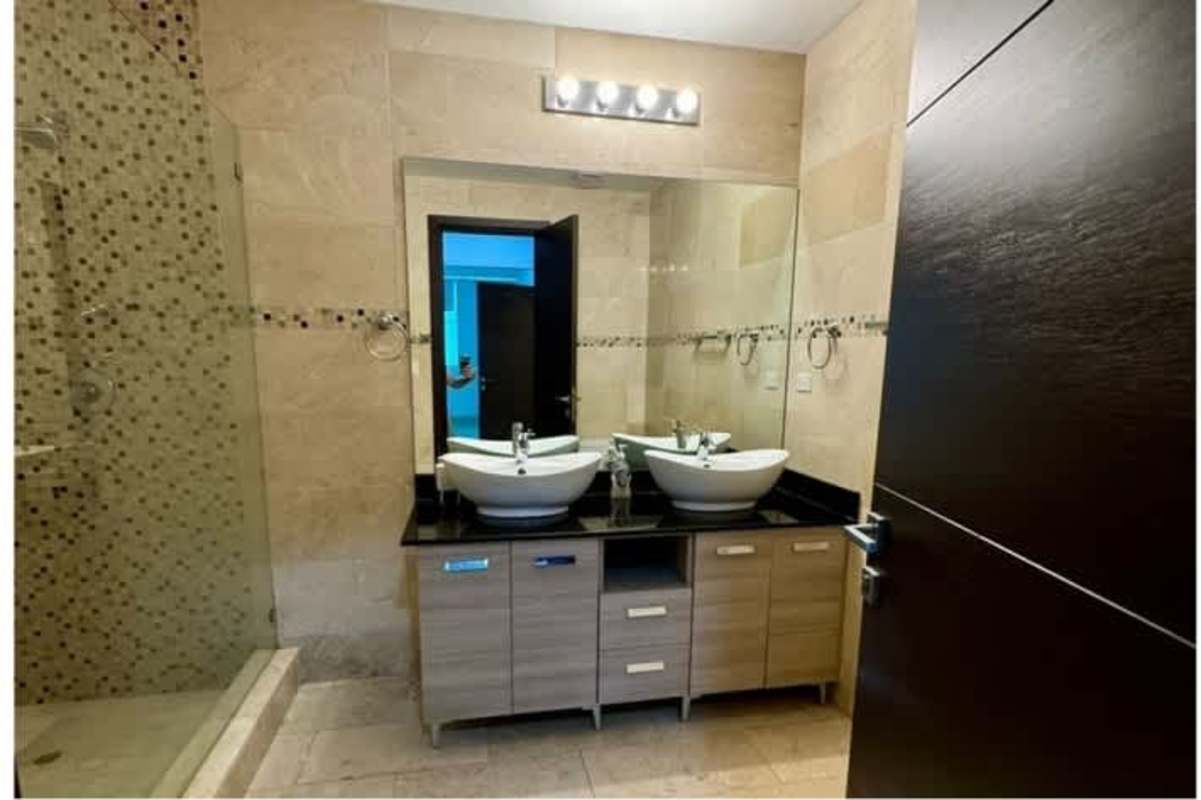 Luxury bathroom with double vessel sinks and glass-enclosed shower at Pacific Point Punta Pacífica